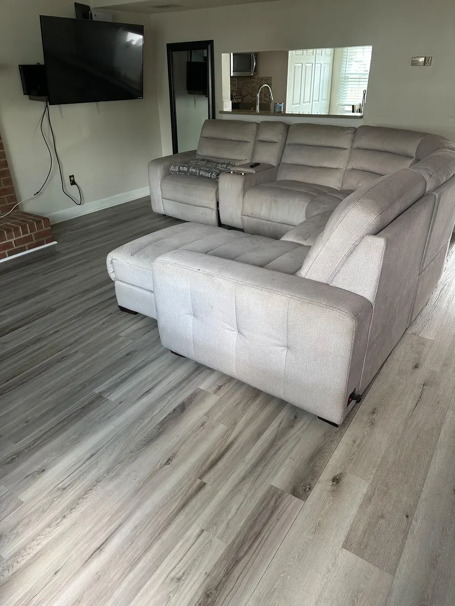 The Beyon Vital living room photographed on a phone: the walls lean inward, the floor fills the lower half of the frame and the picture is dim.